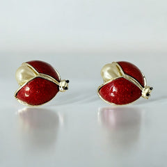 Set of two vintage 1990s ladybug scatter brooches featuring red guilloché enamel wings with a delicate engraved pattern, gold-tone metal, black enamel eyes, and pear-shaped faux pearls nestled between the wings. These whimsical yet elegant brooches add a charming touch to any outfit. Unsigned and in very good vintage condition.