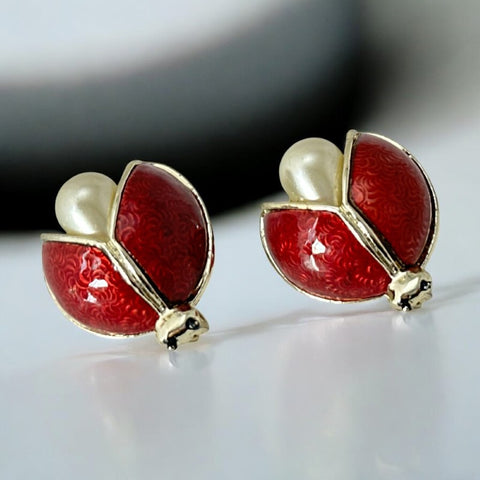 Set of two vintage 1990s ladybug scatter brooches featuring red guilloché enamel wings with a delicate engraved pattern, gold-tone metal, black enamel eyes, and pear-shaped faux pearls nestled between the wings. These whimsical yet elegant brooches add a charming touch to any outfit. Unsigned and in very good vintage condition.