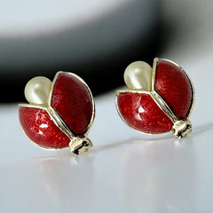 Set of two vintage 1990s ladybug scatter brooches featuring red guilloché enamel wings with a delicate engraved pattern, gold-tone metal, black enamel eyes, and pear-shaped faux pearls nestled between the wings. These whimsical yet elegant brooches add a charming touch to any outfit. Unsigned and in very good vintage condition.