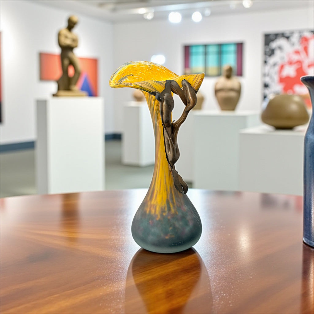 Vintage Romanian art glass vase from the 1990s featuring a frosted teal base, vibrant yellow flared top, and sculptural bronze overlay. Signed by the artist near the base. Elegant and expressive, with subtle surface variation and rich color contrast.