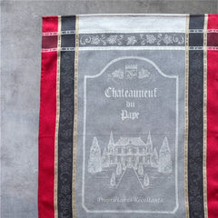 Provence tea towel featuring Châteauneuf-du-Pape winery chateau design with gray background and red and brown striped borders. Made of 100% cotton, ideal for wine-inspired kitchen decor and rustic elegance.