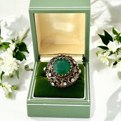 Vintage 1990s Turkish Sultan-style adjustable ring featuring a faceted emerald glass cabochon, clear rhinestones, and ornate antiqued bronze detailing in very good condition.