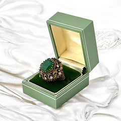 Vintage 1990s Turkish Sultan-style adjustable ring featuring a faceted emerald glass cabochon, clear rhinestones, and ornate antiqued bronze detailing in very good condition.