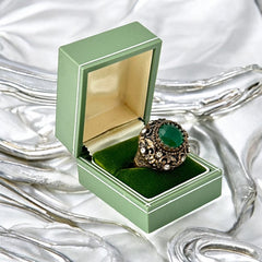 Vintage 1990s Turkish Sultan-style adjustable ring featuring a faceted emerald glass cabochon, clear rhinestones, and ornate antiqued bronze detailing in very good condition.
