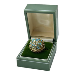 Vintage gold-tone dome cocktail ring featuring faux turquoise, peridot rhinestones, and faux seed pearls with a textured shank. Adjustable on one side and estimated from the 1990s, in good vintage condition.