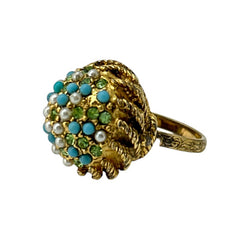 Vintage gold-tone dome cocktail ring featuring faux turquoise, peridot rhinestones, and faux seed pearls with a textured shank. Adjustable on one side and estimated from the 1990s, in good vintage condition.