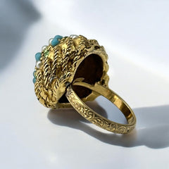 Vintage gold-tone dome cocktail ring featuring faux turquoise, peridot rhinestones, and faux seed pearls with a textured shank. Adjustable on one side and estimated from the 1990s, in good vintage condition.