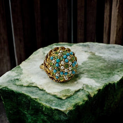 Vintage gold-tone dome cocktail ring featuring faux turquoise, peridot rhinestones, and faux seed pearls with a textured shank. Adjustable on one side and estimated from the 1990s, in good vintage condition.
