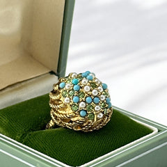 Vintage gold-tone dome cocktail ring featuring faux turquoise, peridot rhinestones, and faux seed pearls with a textured shank. Adjustable on one side and estimated from the 1990s, in good vintage condition.