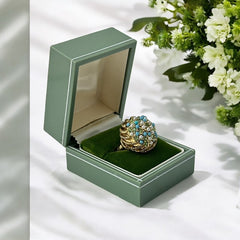 Vintage gold-tone dome cocktail ring featuring faux turquoise, peridot rhinestones, and faux seed pearls with a textured shank. Adjustable on one side and estimated from the 1990s, in good vintage condition.