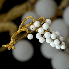 Vintage milk glass brooch featuring three single beads and a grape cluster hanging from textured gold-tone branches, possibly unsigned Marvella from the 1970s/80s, in very good condition with a whimsical and elegant design.