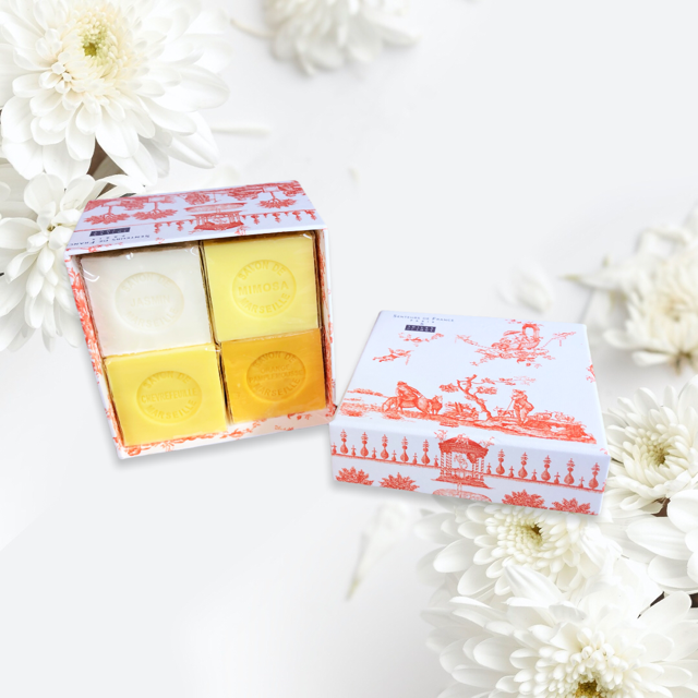 Orange Toile de Jouy gift box with vibrant patterns, containing four artisanal Marseille cube soaps in Honeysuckle, Mimosa, Orange-Grapefruit, and Jasmine fragrances.