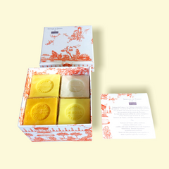Orange Toile de Jouy gift box with vibrant patterns, containing four artisanal Marseille cube soaps in Honeysuckle, Mimosa, Orange-Grapefruit, and Jasmine fragrances.