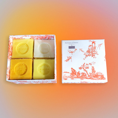 Orange Toile de Jouy gift box with vibrant patterns, containing four artisanal Marseille cube soaps in Honeysuckle, Mimosa, Orange-Grapefruit, and Jasmine fragrances.
