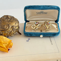 Vintage light gold‑tone floral clip‑on earrings with AB topaz rhinestones in a mid‑century design.