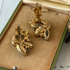 Vintage gold‑tone floral clip‑on earrings with iridescent AB marquise and round rhinestones reflecting rainbow hues.