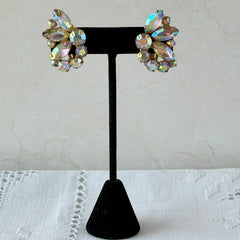 Vintage gold‑tone floral clip‑on earrings with iridescent AB marquise and round rhinestones reflecting rainbow hues.