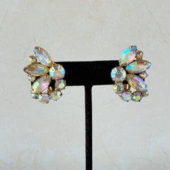 Vintage gold‑tone floral clip‑on earrings with iridescent AB marquise and round rhinestones reflecting rainbow hues.