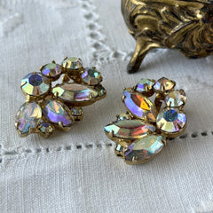 Vintage gold‑tone floral clip‑on earrings with iridescent AB marquise and round rhinestones reflecting rainbow hues.