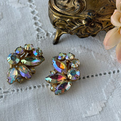 Vintage gold‑tone floral clip‑on earrings with iridescent AB marquise and round rhinestones reflecting rainbow hues.