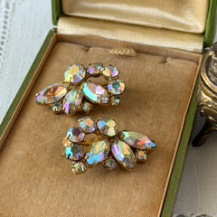 Vintage gold‑tone floral clip‑on earrings with iridescent AB marquise and round rhinestones reflecting rainbow hues.