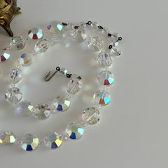 Vintage AB crystal coin necklace with large faceted iridescent beads, clear spacers, and an adjustable hook clasp, shown on a display stand and in close‑up views.