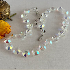 Vintage AB crystal coin necklace with large faceted iridescent beads, clear spacers, and an adjustable hook clasp, shown on a display stand and in close‑up views.