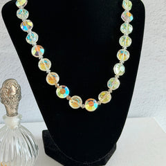 Vintage AB crystal coin necklace with large faceted iridescent beads, clear spacers, and an adjustable hook clasp, shown on a display stand and in close‑up views.