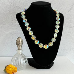 Vintage AB crystal coin necklace with large faceted iridescent beads, clear spacers, and an adjustable hook clasp, shown on a display stand and in close‑up views.