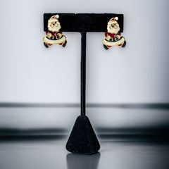 Vintage AIM Santa earrings with red, white, and black enamel, signed with copyright mark, featuring movable head and pierced stud design.