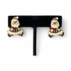 Vintage AIM Santa earrings with red, white, and black enamel, signed with copyright mark, featuring movable head and pierced stud design.