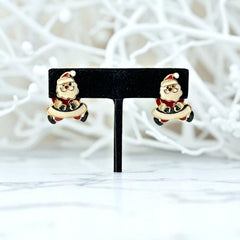 Vintage AIM Santa earrings with red, white, and black enamel, signed with copyright mark, featuring movable head and pierced stud design.