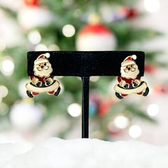 Vintage AIM Santa earrings with red, white, and black enamel, signed with copyright mark, featuring movable head and pierced stud design.
