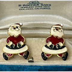 Vintage AIM Santa earrings with red, white, and black enamel, signed with copyright mark, featuring movable head and pierced stud design.
