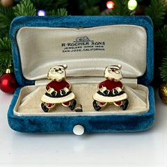 Vintage AIM Santa earrings with red, white, and black enamel, signed with copyright mark, featuring movable head and pierced stud design.