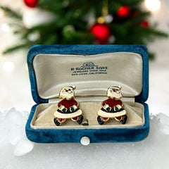 Vintage AIM Santa earrings with red, white, and black enamel, signed with copyright mark, featuring movable head and pierced stud design.