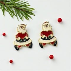 Vintage AIM Santa earrings with red, white, and black enamel, signed with copyright mark, featuring movable head and pierced stud design.