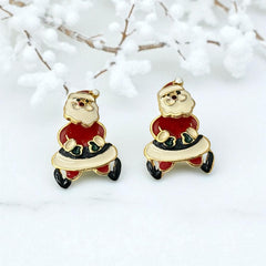Vintage AIM Santa earrings with red, white, and black enamel, signed with copyright mark, featuring movable head and pierced stud design.
