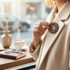 Vintage ART signed Christmas wreath brooch with red and white enamel, multicolor rhinestones, gold-tone openwork design, and red bow; mid-century holiday jewelry in very good condition.