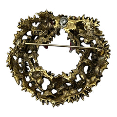 Vintage ART signed Christmas wreath brooch with red and white enamel, multicolor rhinestones, gold-tone openwork design, and red bow; mid-century holiday jewelry in very good condition.