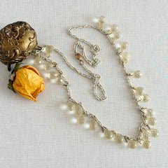 Vintage 1990s long necklace with acrylic faceted briolettes on a mixed‑metal chain, displayed with vintage props.