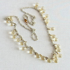 Vintage 1990s long necklace with acrylic faceted briolettes on a mixed‑metal chain, displayed with vintage props.