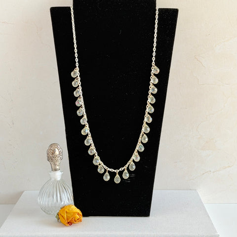 Vintage 1990s long necklace with acrylic faceted briolettes on a mixed‑metal chain, displayed with vintage props.