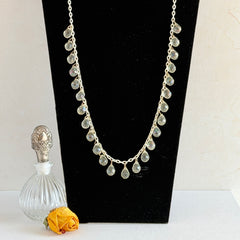 Vintage 1990s long necklace with acrylic faceted briolettes on a mixed‑metal chain, displayed with vintage props.