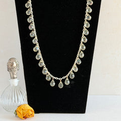 Vintage 1990s long necklace with acrylic faceted briolettes on a mixed‑metal chain, displayed with vintage props.