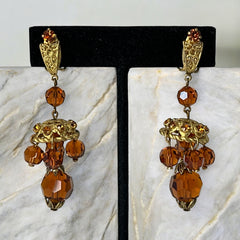 Vintage gold-tone clip-on earrings with honey topaz faceted crystals and ornate filigree dangle design.
