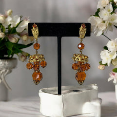 Vintage gold-tone clip-on earrings with honey topaz faceted crystals and ornate filigree dangle design.