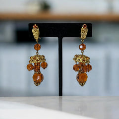 Vintage gold-tone clip-on earrings with honey topaz faceted crystals and ornate filigree dangle design.