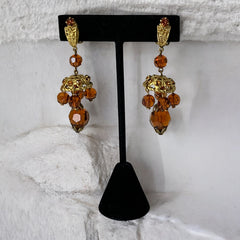 Vintage gold-tone clip-on earrings with honey topaz faceted crystals and ornate filigree dangle design.