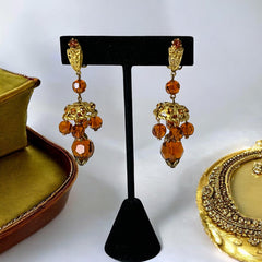 Vintage gold-tone clip-on earrings with honey topaz faceted crystals and ornate filigree dangle design.